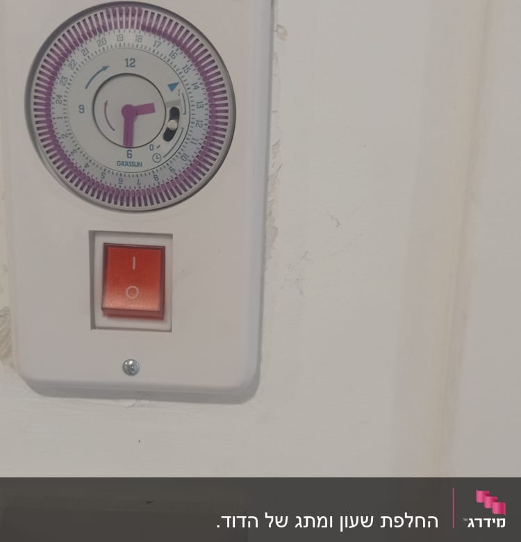 שעון טיימר חשמלי ומתג הפעלה על קיר